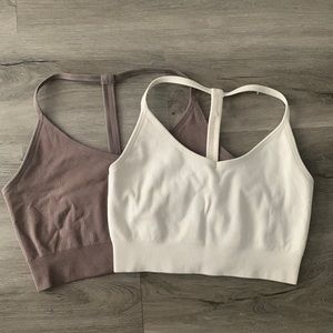 Two white and purple athletic cropped tank tops.
